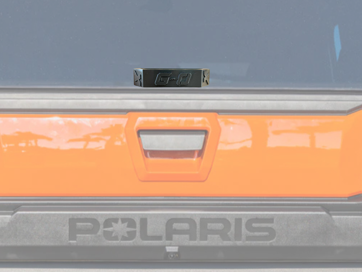 Close-up of a Polaris vehicle door with orange handle and visible branding.