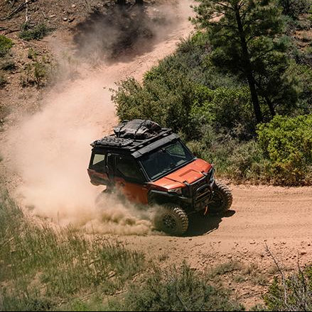 Off-road vehicle driving on a dirt road in a forested area