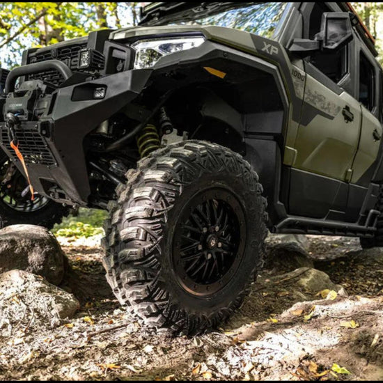 Off-road vehicle navigating a rocky trail in a forest