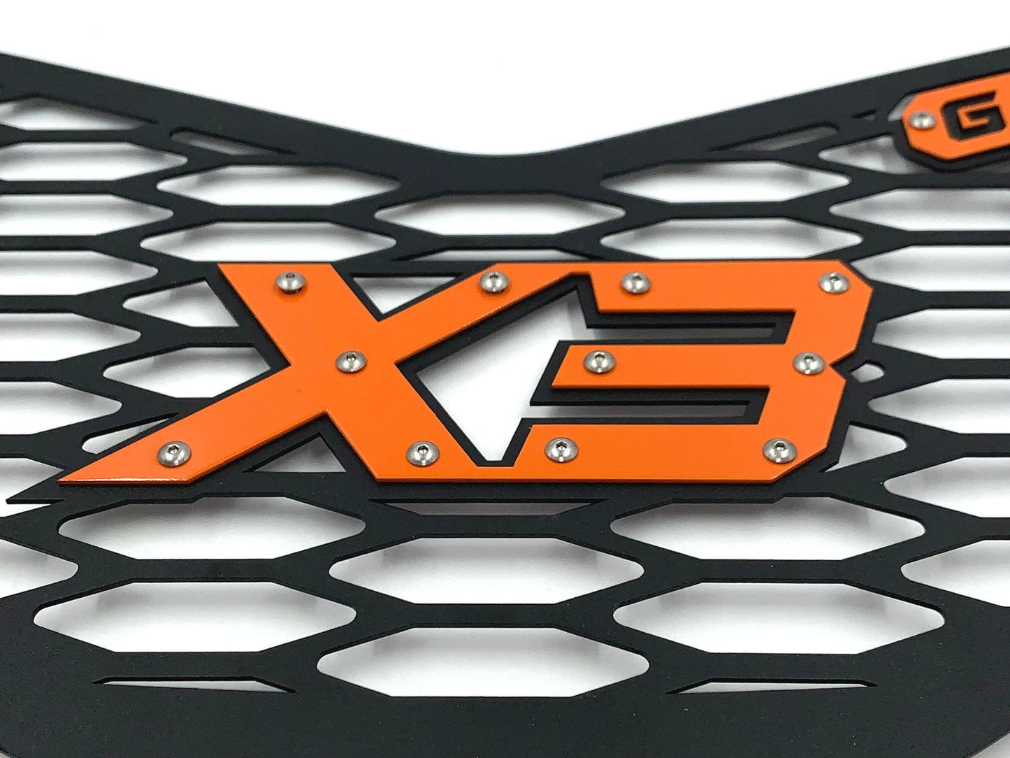 closeup of orange x3 logo on greanland grille