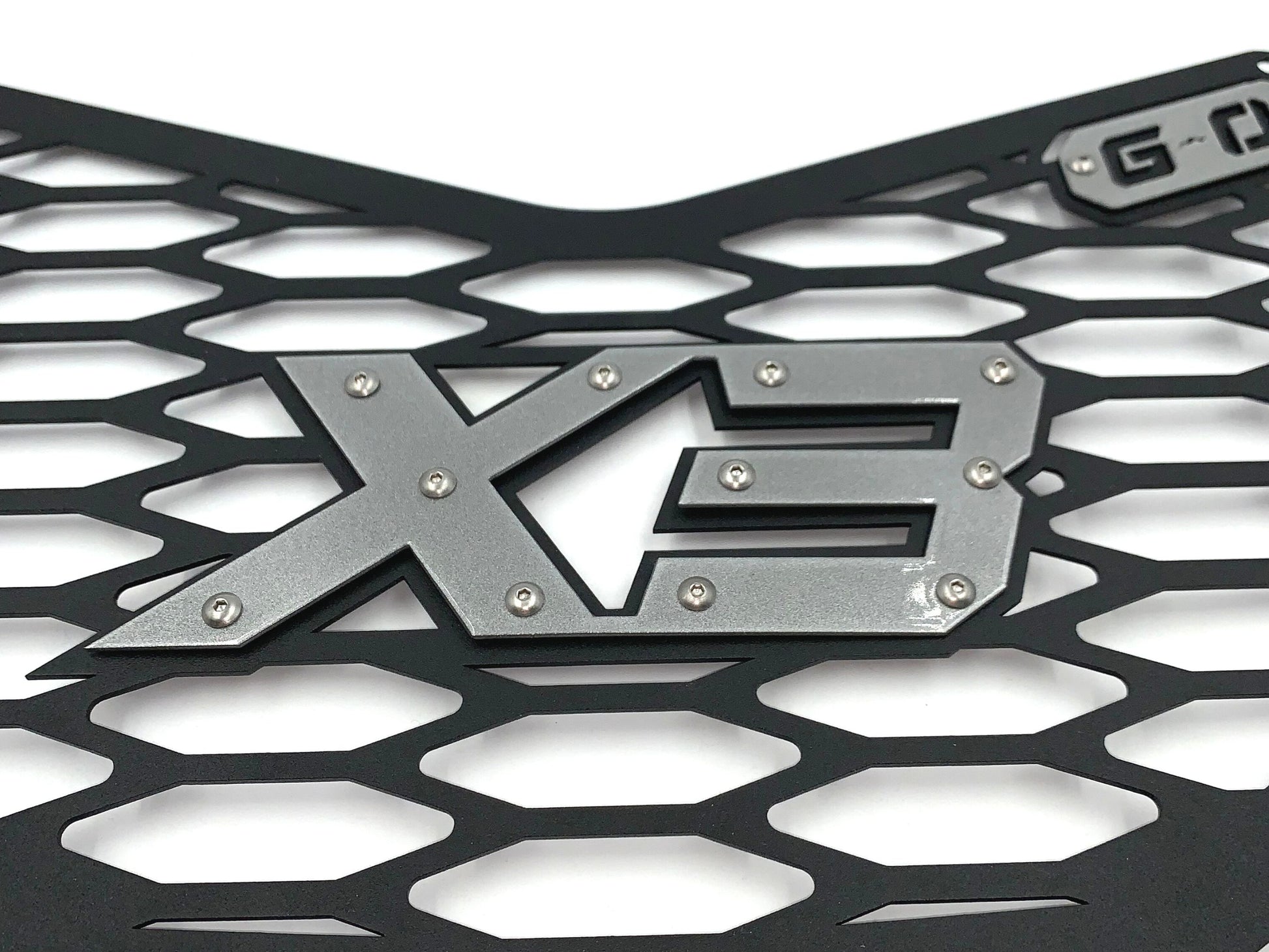 closeup of silver x3 logo on greanland offroad can am x3 grille